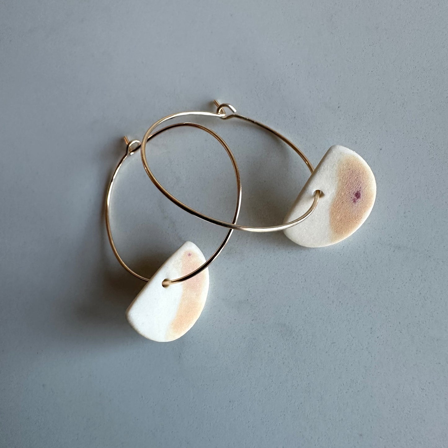 subtle peach and cranberry half-moon hoop earring